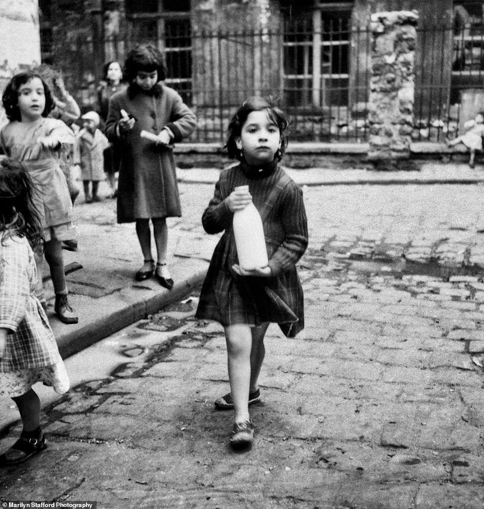 Photographer captured an image of a girl carrying a bottle of milk, Cité Lesage-Bullourde, circa 1950