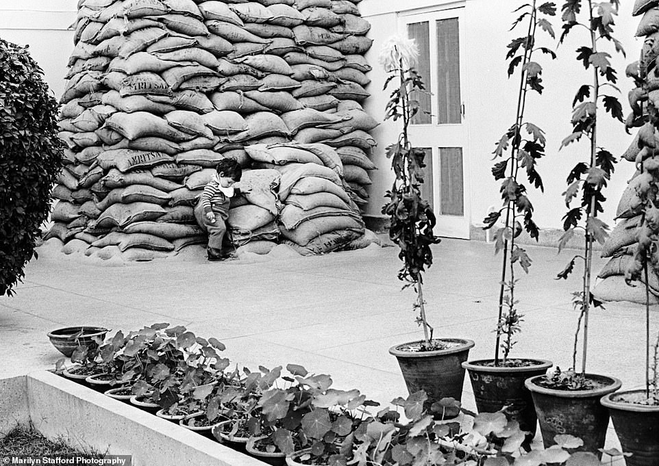 Rahul, grandson of Indira Gandhi, playing next to sandbags that were used to protect his grandmother's house during the Indo-Pakistani War, New Delhi, 1972