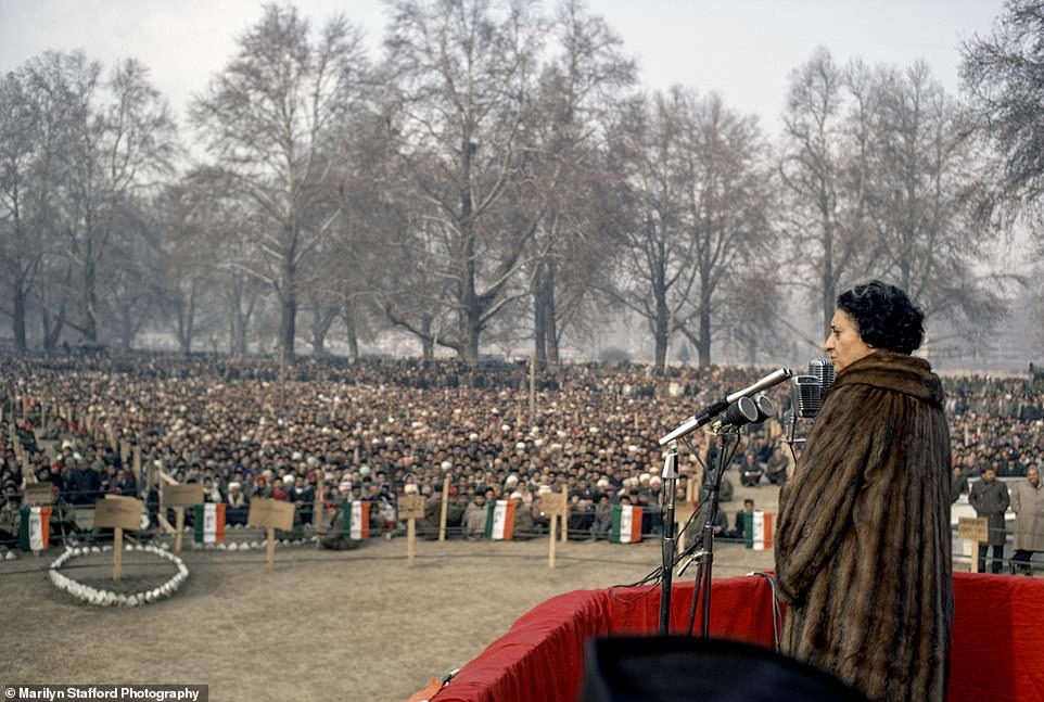 Marilyn Stafford takes a photograph as Indira Gandhi speaks at a mass rally in Kashmir in 1971