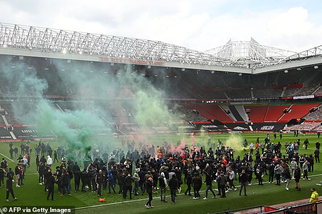 The crowd that breached the Old Trafford perimeter gathered in front of the South Stand, lit smoke flares and chanted