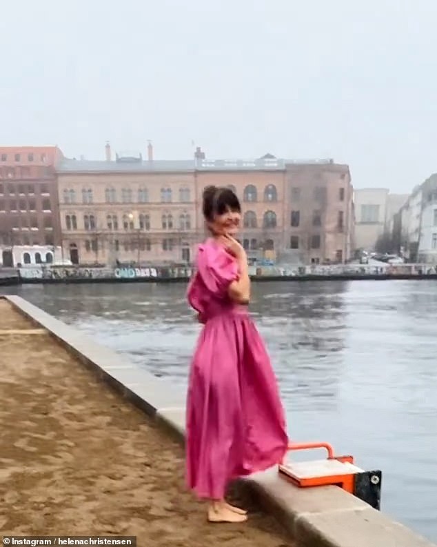 Beautiful: Before heading into the water, she wrapped herself in an elegant pink dress.