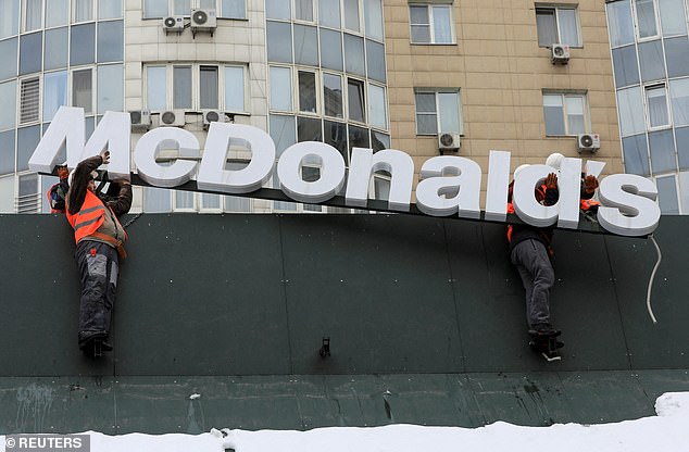 Workers remove logo signage from a McDonald's restaurant in Almaty, Kazakhstan