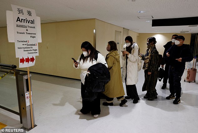 Passengers on a plane from China's capital Beijing arrive and proceed to the coronavirus disease (COVID-19) testing area at Narita International Airport in Narita, east of Tokyo.