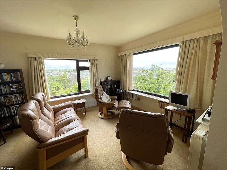 The living room in the bungalow has large windows with extensive views over the Cornish countryside