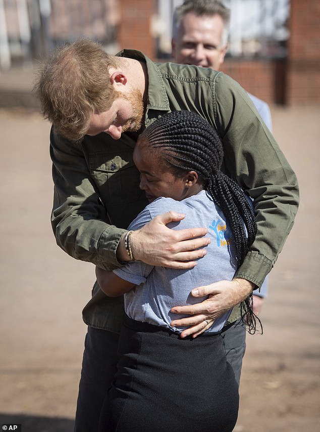 Teenager Tlotlo Moilwa hugs Britain's Prince Harry during a visit to the Kasane Health Post, run by the Sentebale charity, in Kasane, Botswana in 2019.