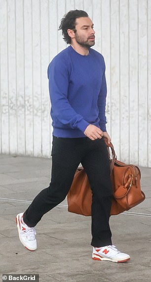 On-trend: Taking to the British capital on Saturday, the Poldark star looked casual in a blue sweater and black trousers