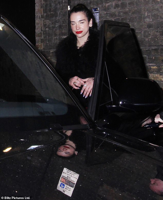 Big night: Dua wore her raven braids in a sleek high ponytail, toting her essentials in a red bag while accessorizing with some silver rings on Saturday night