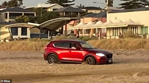 The car got stuck in the sand and its occupants tried unsuccessfully to get the vehicle out.