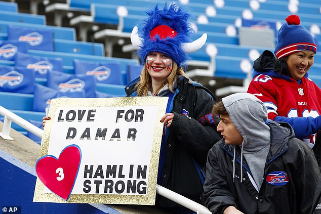 A fan holds up a sign supporting Hamlin before the Bills' game against the Patriots on Sunday.