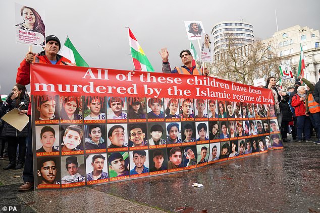 Protesters are seen in London waving flags of Iran used before the 1979 Islamic Revolution