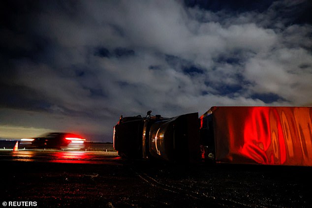 A semi trailer lies on its side after it was blown over by high winds during a winter storm along Interstate 5 in Woodland, California.