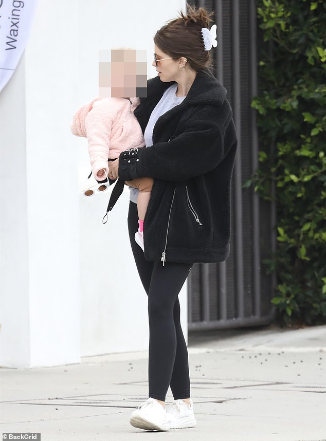 Taking turns: The couple took turns holding their youngest daughter, seven months old, who looked gorgeous in a pink jacket, brown pants and light pink sneakers with bright pink socks