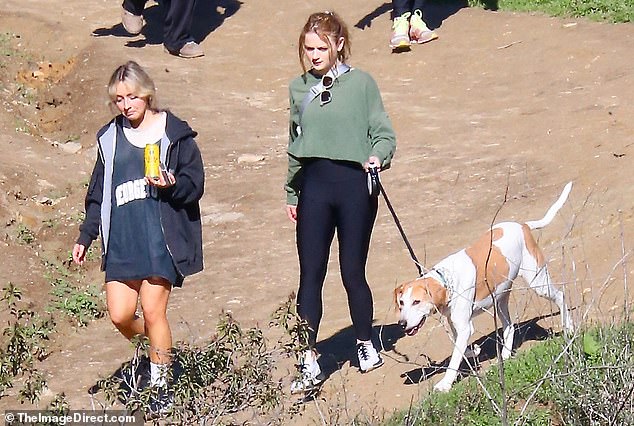 Rising stars: The Kissing Booth actress donned a comfy, athletic outfit appropriate for walking up and down a mountain, wearing a small gray crossbody bag as she kept the precious pooch close