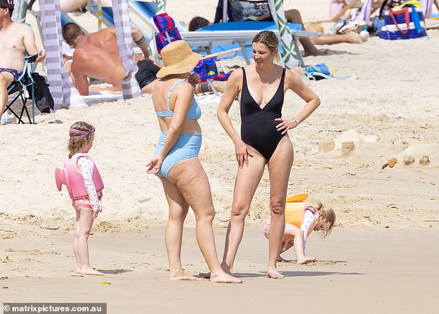 Jasmine was seen chatting with a friend at the beach while her daughter played in the nearby sand.