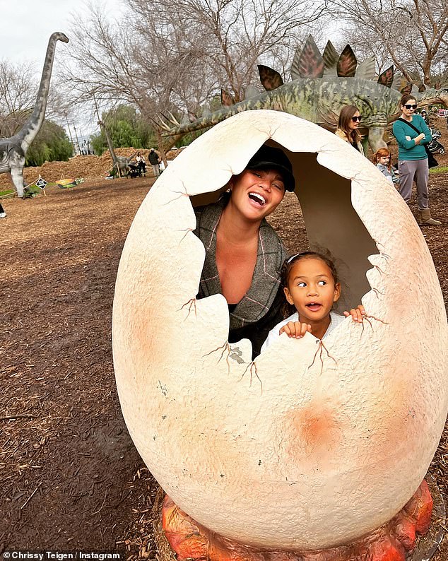 Hatched: The mom-to-be flashed a beaming smile as she stood inside a giant dinosaur egg replica alongside her six-year-old daughter Luna