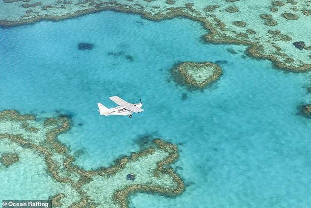 The Great Barrier Reef is shown from above.  Visitors to Airlie Beach can view the reef on a small plane, operated by Ocean Rafting