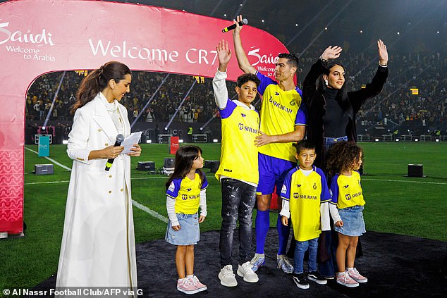 A handout picture released by Saudi Arabia's al-Nassr football club shows Al-Nassr's new Portuguese forward Cristiano Ronaldo (C) alongside his partner Georgina Rodriguez (C-R) and their children greeting the crowd during his unveiling at the Mrsool Park Stadium in the Saudi capital Riyadh on January 3, 2023