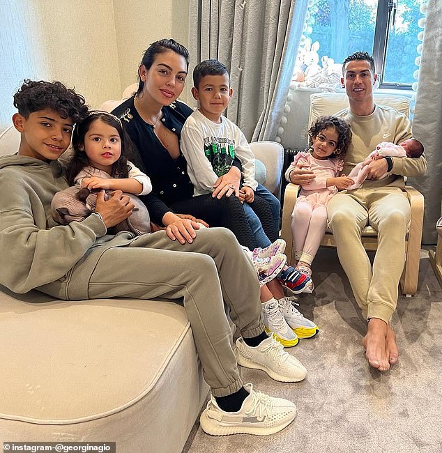 12-year-old Cristiano Jr. (pictured left) hugs his baby sister Eva while Ronaldo's girlfriend Georgina Rodriguez cradles Mateo on her lap, Cristiano (pictured right) holds his two daughters baby Bella and Alana Martina