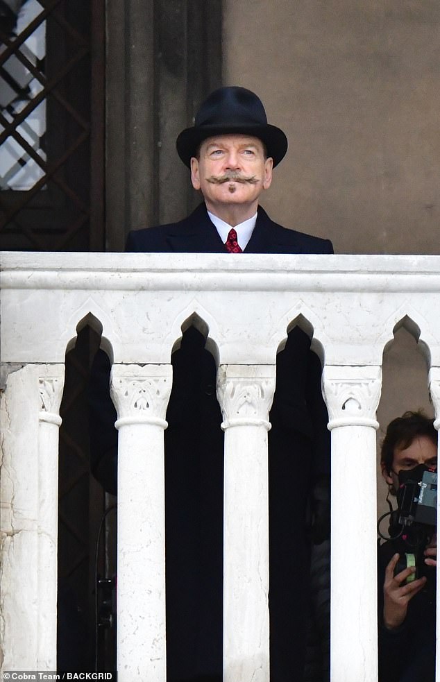 Period Suit: Kenneth donned a double-breasted navy coat over his matching suit, which was teamed with a crisp white shirt and red tie.