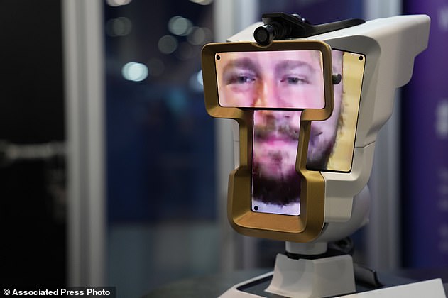 A man looks onto the show floor from a Wehead spatial video communication device at the Wehead booth during the CES tech show Friday, Jan. 6, 2023, in Las Vegas. The device, controlled via a smartphone, laptop, or tablet, allows the user to remotely look around through the device's camera and observe the environment an interact with people in the room. (AP Photo/John Locher)