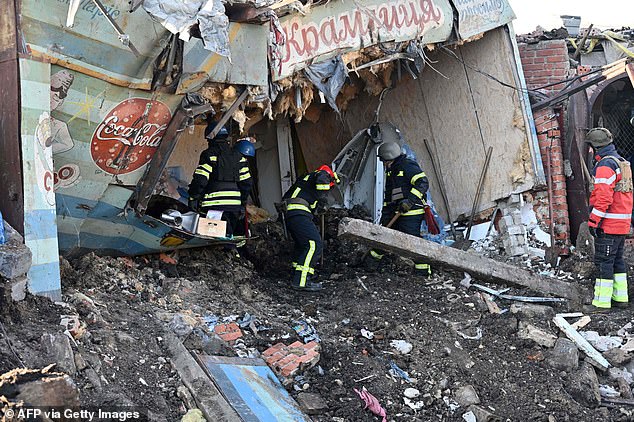 Ukrainian rescuers work on the site following a Russian missile strike on a local market in Shevchenkove village, Kharkiv region