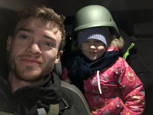 Christopher Parry is pictured with a girl whose family he helped to rescue from the front lines