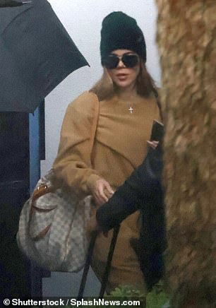 Back home: Khloe was wearing a tan outfit and a black hat when she returned to Los Angeles