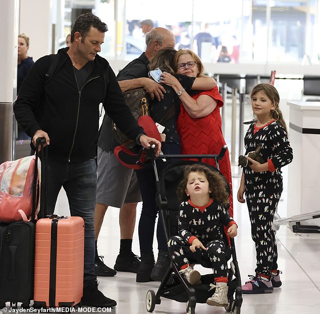 The South African-born Australian actress, 39, hugged her mother Julie and father Daryl tightly at the airport after their family checked their luggage.