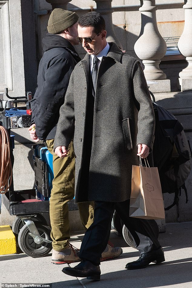 Jeremy's look: Strong was seen sporting a traditional black suit with a gray-brown coat, along with aviator sunglasses while carrying a brown grocery bag.