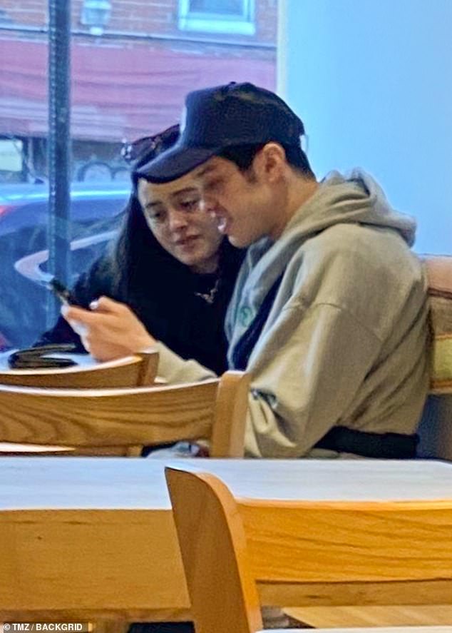 Cuddly: The former SNL star, 29, and his co-star, 26, were waiting for their takeout according to TMZ, with Chase affectionately holding his arm around the comedian as he showed him something on his phone