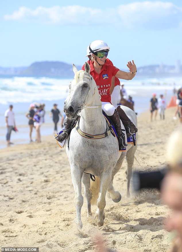 Olympian Zara, 41, looked stylish in her equestrian gear, opting for white pants, a red polo shirt and white sneakers, before donning boots for a walk on the beach.