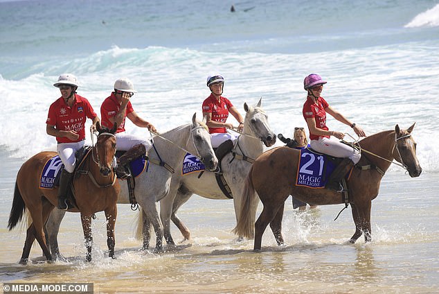 Zara (center) is pictured with her horse in the ocean before going for a walk on the beach.