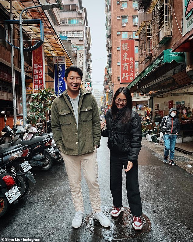 Cuddling up: Shang-Chi, 33, and the Legend of the Ten Rings actor stood together in the middle of a city street, cuddling up in the image