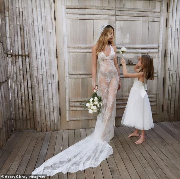 With her mini-me: barefoot bride Abbey shared a sweet moment with her daughter before heading to the beach