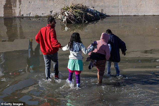 Immigrants cross the Rio Grande River into El Paso, Texas on January 8, 2023 from Ciudad Juárez, Mexico, the same day as Biden's visit