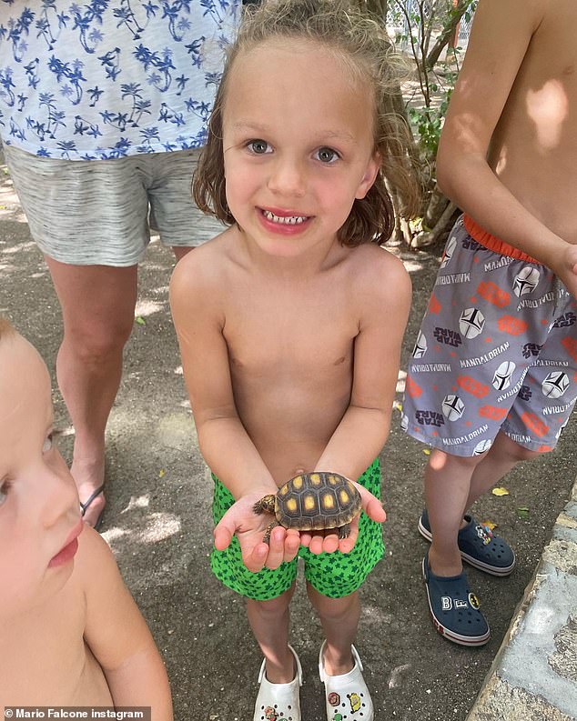 Beaming: In another snap, Parker smiled while holding on to a small tortoise