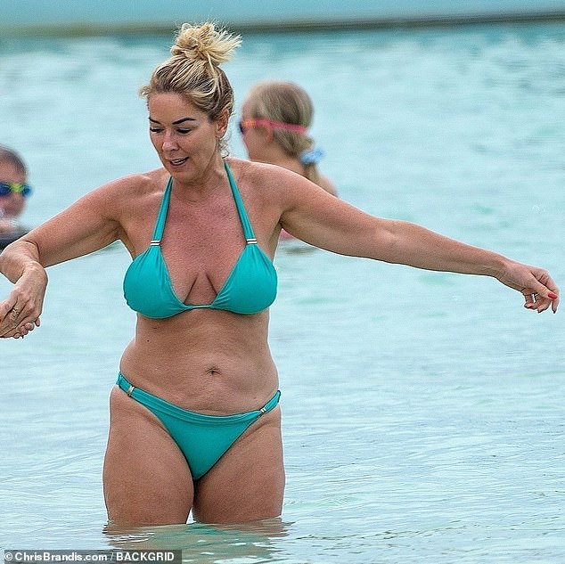 Brimming with confidence: Claire looked fabulous in her aquamarine halter-neck swimsuit with gold accents, which highlighted her tanned figure