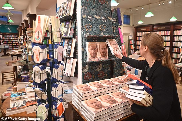 A bookseller preparing a display for Spare at Daunt Books in Marylebone High Street