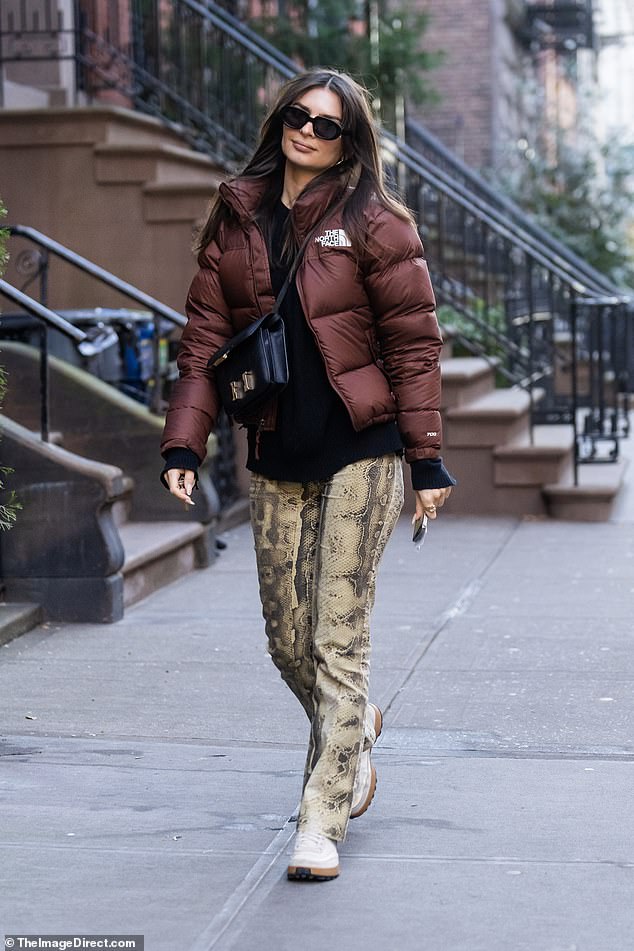 Uncomplicated: She showed some of her casual fashion sense in a burgundy North Face puffy jacket, which she wore with a black sweatshirt, snake-print pants, and white sneakers.