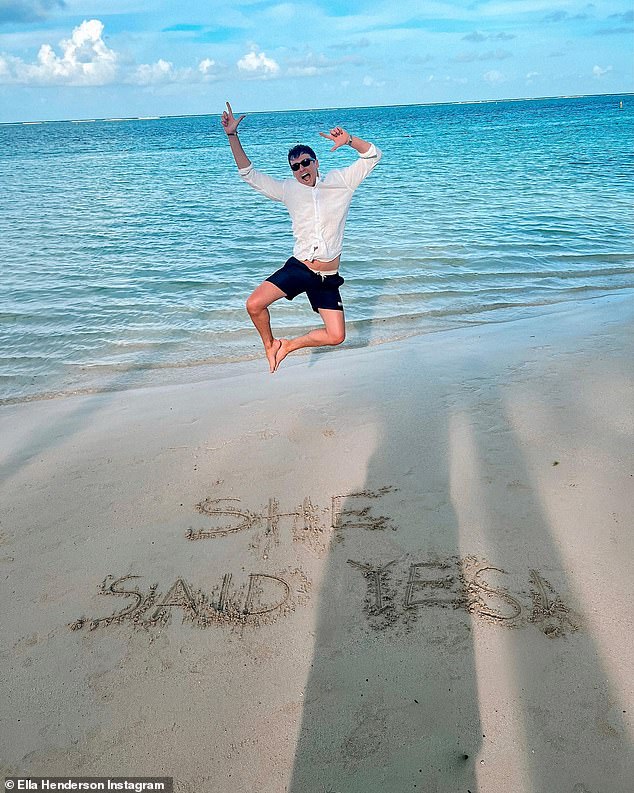 Cute: Another snapshot showed Jack jumping for joy on the beach with the words 'she said yes!'  written in the sand in front of him