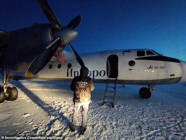 Investigators examine the An-26 after its rear door opened soon after takeoff, terrifying passengers