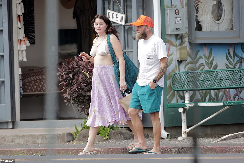 Keeping it casual: The Superbad star opted for a pop of color in her ensemble for the day, wearing teal shorts along with a vibrant orange cap to cover up her locks