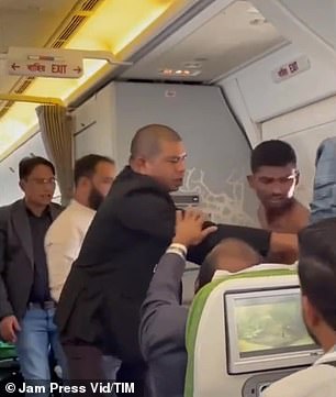 In the footage, the shirtless man appears to be trying to pry the other passenger out of his front row seat on the Boeing 777 plane.