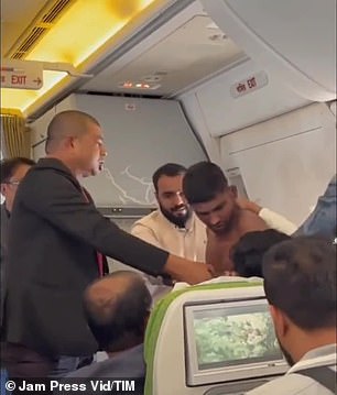 A male passenger grabs her wrist and briefly her neck in an attempt to separate the two.