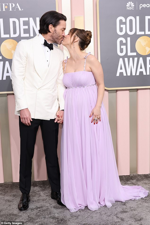 Kiss: The expectant couple shared a sweet kiss on the red carpet