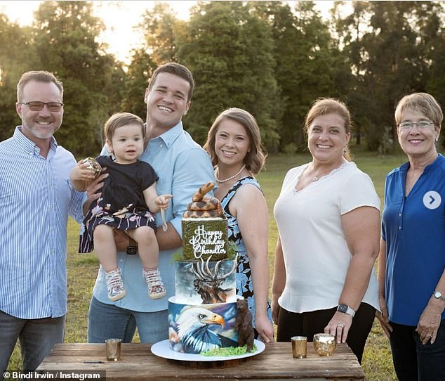 The couple celebrated Chandler's 26th birthday on November 14 with fans pointing out that Bindi was hiding her stomach behind a strategically placed birthday cake.  Pictured here with his family from Florida