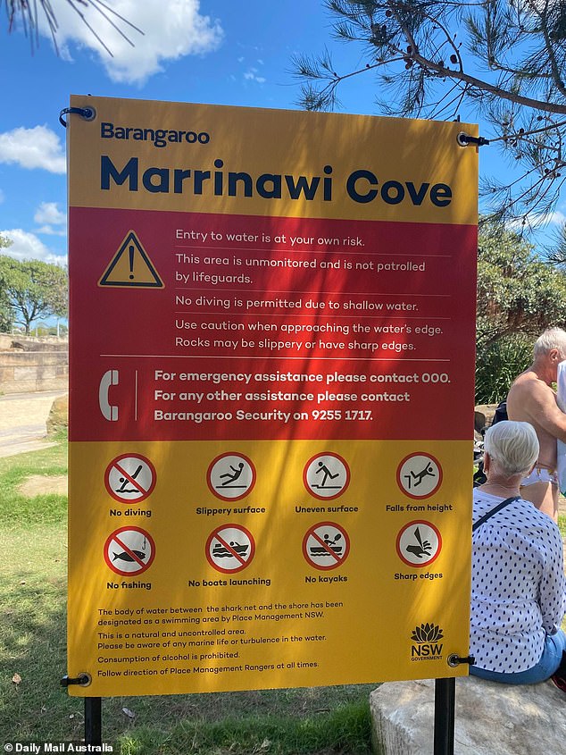 A sign next to the watering hole warns swimmers of the slippery and uneven surface