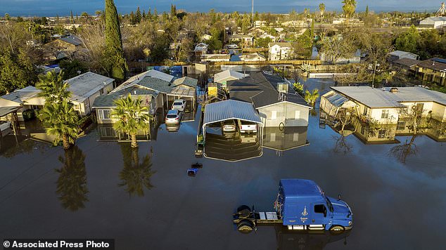 After days of rain, floodwaters surround homes and vehicles in the Planada community of Merced County, California on Tuesday.