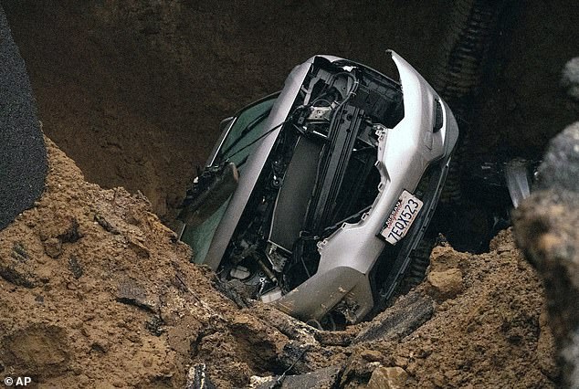 Two cars were swallowed by the sinkhole that opened Monday night.