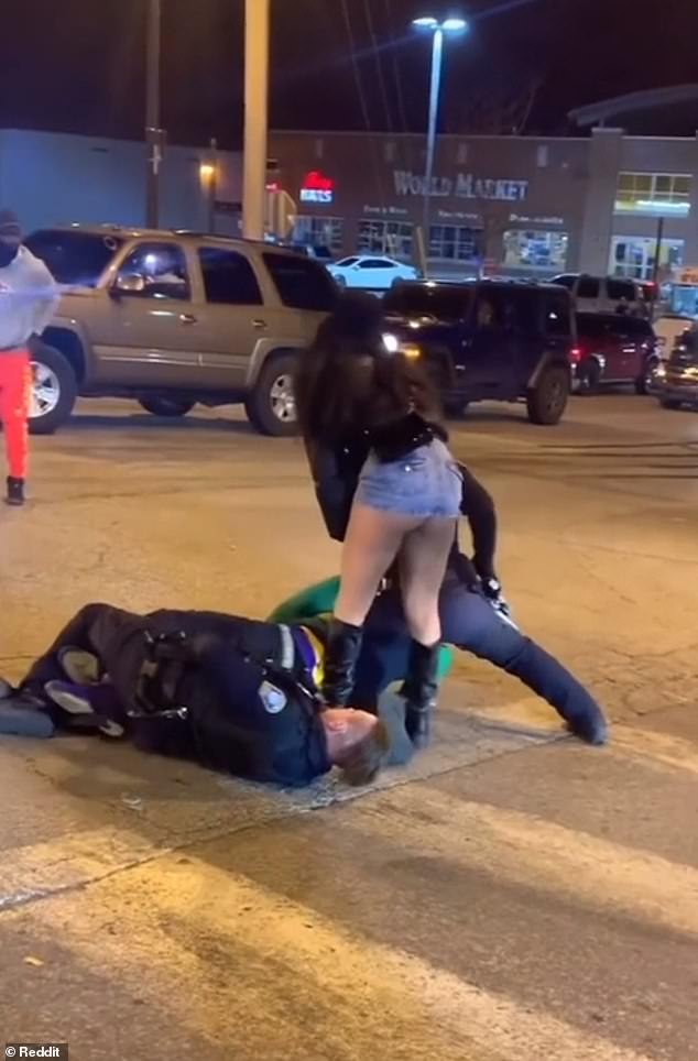 As he leaves the scene, he is replaced by a woman in a leather jacket and jean shorts who confronts the guards.